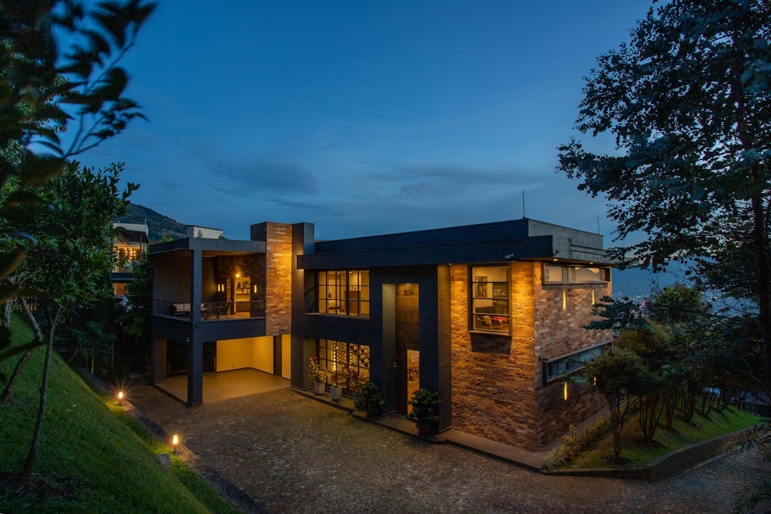 Luxurious villa exterior at dusk with pool and garden lighting
