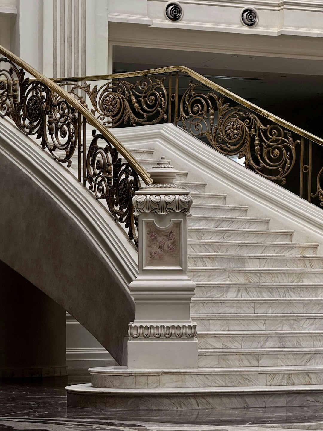 Close-up of an elegant marble staircase with brass railing